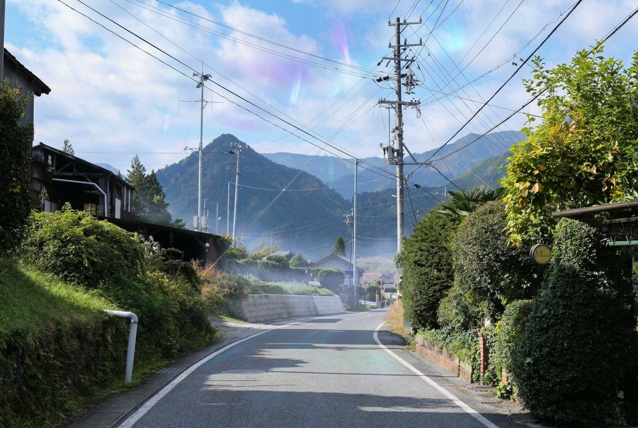 A rural field in Aomori beneath a spectral sky, the kind of landscape that hides the conduit in plain sight